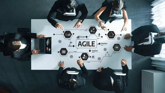 A business team collaborates using agile methodologies in a modern office. They incorporate virtual reality technology to enhance communication and innovative solutions. Amity