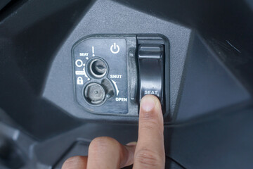 Finger pressing scooter seat release button
