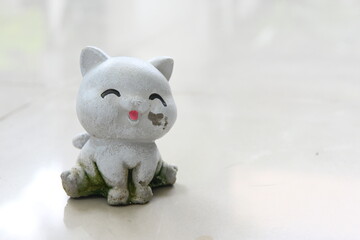 A damaged and dirty cat plaster sculpture.