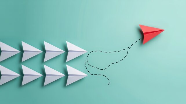 One brightly colored paper glider deviates from a formation of identical white gliders, illustrating independence and change.