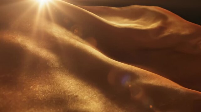 Cinematic slow motion close-up of luxurious amber and gold silk fabric rippling gently while catching intense golden hour sun flares and highlights high quality, elegant, beautiful
