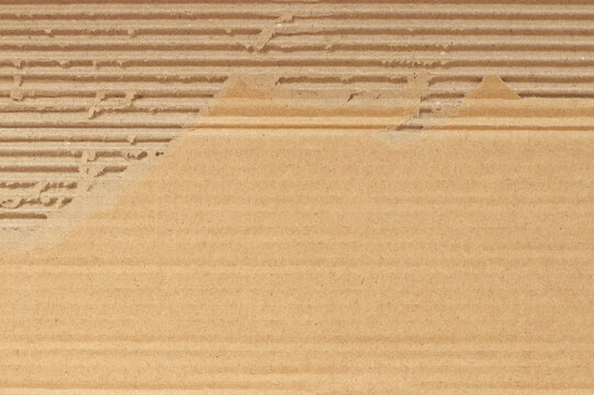 Brown cardboard sheet abstract background, texture of recycle paper box in old vintage pattern with ripped edges.