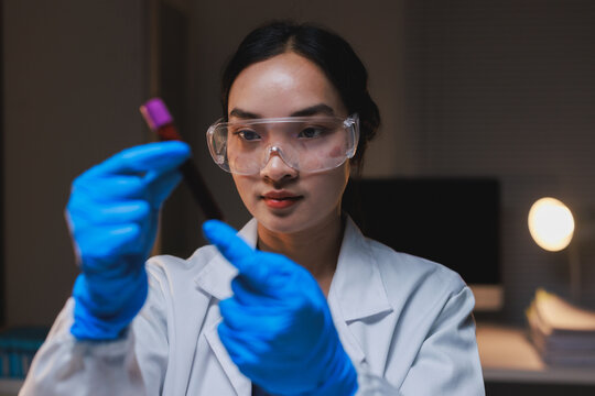 Scientist examining blood sample tube in laboratory