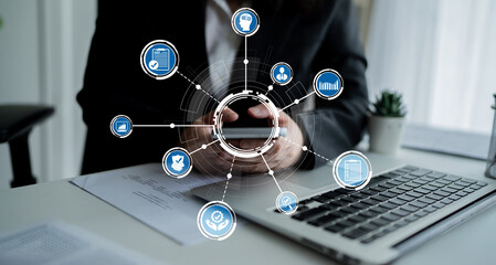 A business professional engages with digital icons symbolizing technology and data management, showcasing the blend of innovation and modern work environments. Crux
