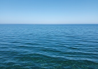 Vast, tranquil saltwater surface shimmering with gentle ripples under natural light. The expansive blue liquid creates a serene and pure natural background ,climate ,current ,peace