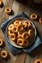 Plate of small ring shaped bagels on a wooden table