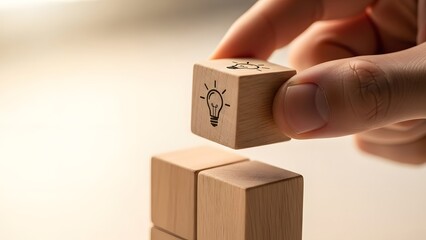 Hand stacking light bulb icon block for business innovation and idea development