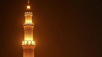 Stunning golden minaret glowing against the night sky, a beacon of faith and architectural beauty, perfect for travel, culture, or religious themes