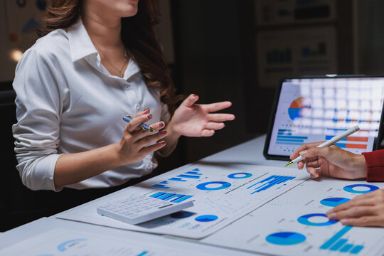 Businesswomen discussing financial data and market strategy