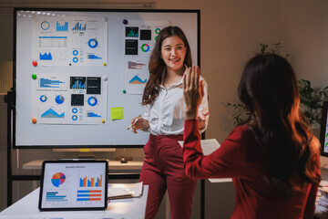 Businesswoman presenting data analysis in modern office meeting