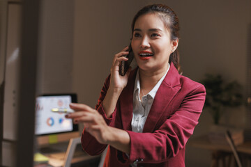 Young businesswoman talking on smartphone managing work