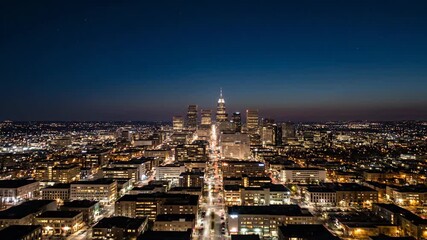 Vertical timelapse of a city skyline transitioning from sunset to night. Aerial view of downtown skyscrapers and illuminated traffic lights. Urban energy and modern city life