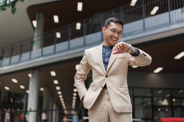 Businessman checking time smiling in modern building