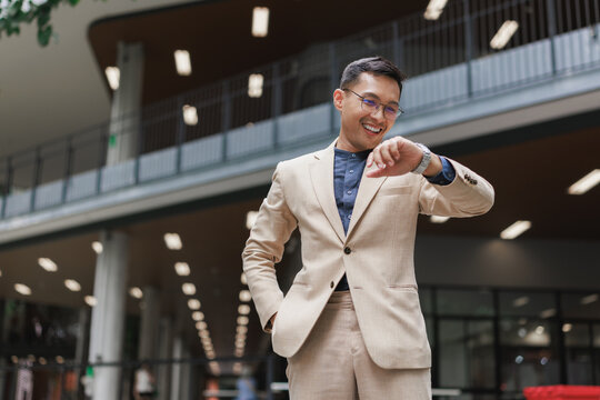 Businessman checking time smiling in modern building