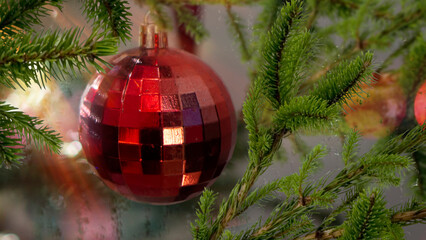 Bright red Christmas balloon on a green Christmas tree.