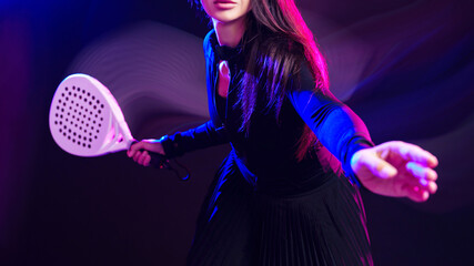 Woman playing racquet sport with focus and energy in a vibrant setting