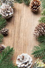 Christmas pine cones and fir branches on wooden background