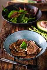 Freshly prepared steak salad served on wooden dining table