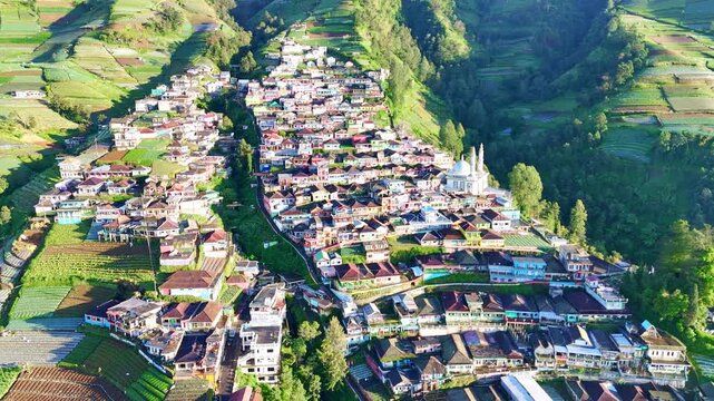 Vibrant aerial landscape of a mountain village with rainbow-colored houses among green hills on the Slope of Mount Sumbing, Indonesia. Nepal Van Java.