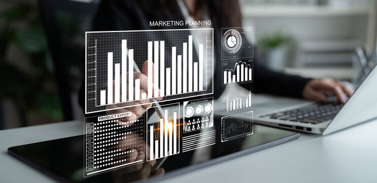 A business professional uses a laptop to engage in marketing planning, analyzing digital analytics displayed on a sleek dashboard in a modern workspace. Impute - Powered by Adobe