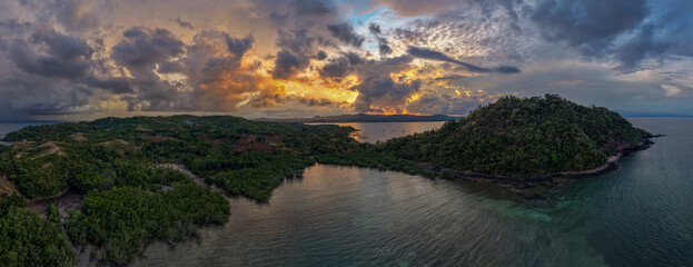 Panoramic sunrise aerial of Sakatia Island, Nosy Be, Madagascar &ndash; golden light over the ocean, tropical coastline, and peaceful island landscape.