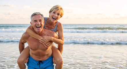 Happy senior couple laughing on the beach. Active mature man giving a woman a piggyback ride during a summer vacation. Healthy retirement lifestyle concept with copy space