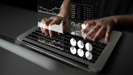 Hands actively typing on a laptop keyboard display holographic financial graphs, charts, and data metrics, showcasing modern analysis and technology in a workspace. Impute
