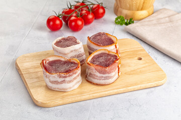 Raw pork tenferloin with bacon