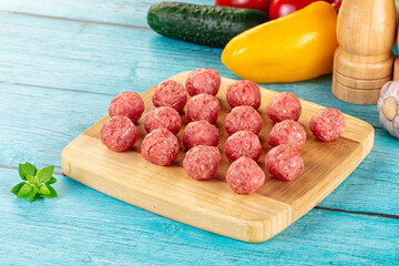 Raw beef meatballs over board