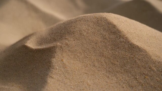 Close-up of golden desert sand dunes showing intricate patterns and natural textures under soft light, evoking a sense of calm and vastness in a serene landscape