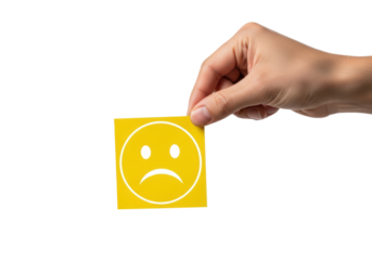 tanned human hand delicately pinching a sharp yellow paper cutout representing a simple sad face low rating icon, isolated macro shot on a high-key white background, concept of low satisfaction and