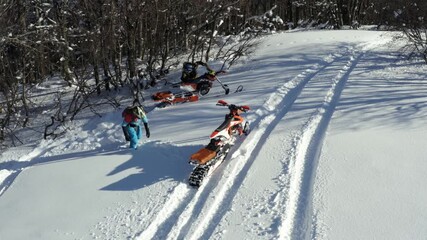 Aerial view of motorbikes with snow tracks riding in snowy mountain landscape