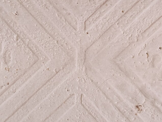 Close-up abstract background of pale cream textured concrete wall with diagonal cross pattern design element