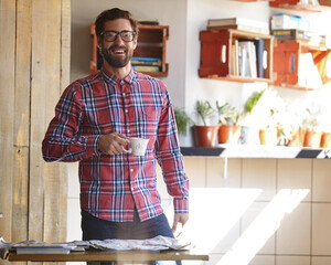 Man, coffee and portrait in kitchen for morning, drink and relax with confidence in home. Happy person, smile and cup with newspaper, laugh and positive mindset with warm beverage in apartment