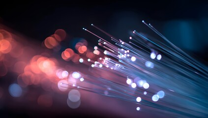 Abstract close up view of glowing fiber optic strands transmitting data with soft bokeh lights in a dark background