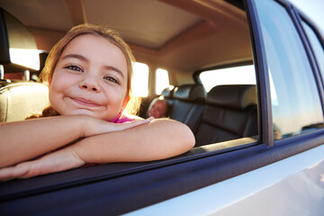 Portrait, child and travel by car window for road trip, holiday or family vacation with girl. Kid, tourism and smile in transport for adventure, journey and happy passenger relax in motor vehicle