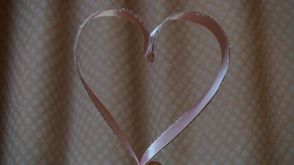 Elegant satin ribbon gracefully unfurls against a textured peach backdrop, perfect for adding a touch of luxury to your creative projects - Powered by Adobe