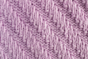 Purple wool yarn, handmade relief pattern, close-up of a piece of clothing