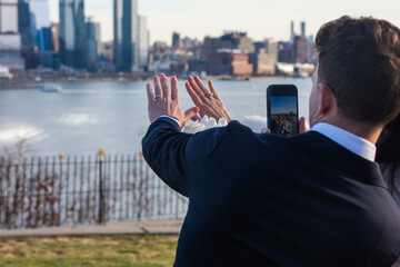 Bride and groom showing off their rings in front of Manhattan skyline.