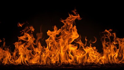 Vibrant orange and yellow flames dance intensely against a deep black background creating a powerful visual display of pure combustion and heat