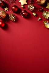 Fototapeta premium Elegant Christmas border of golden and red holiday ornaments on a vertical red background.