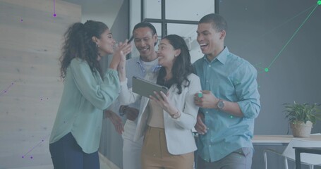 Discussing four coworkers in white blazer reviewing tablet in modern office, showing data overlay
