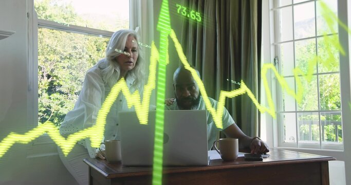 Leaning woman in white blouse, man using laptop by garden windows at home, neon green chart