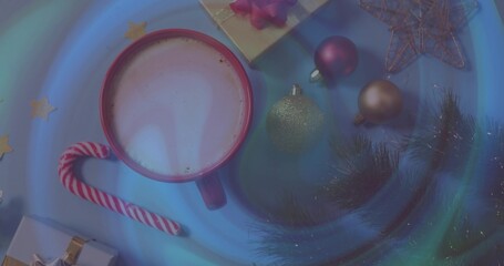 Sitting red ceramic mug frothing on tabletop with candy cane, wrapped gift, ornaments, evergreen © vectorfusionart