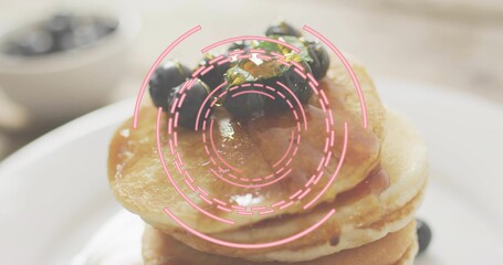 Displaying stack of pancakes sitting on white plate at table, with syrup blueberries pink overlay