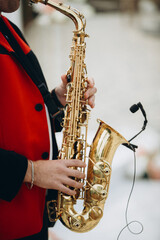 Obraz premium Musician playing golden saxophone with microphone during performance