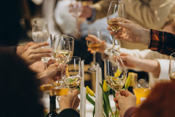 Hands toasting wine glasses at celebratory dinner event