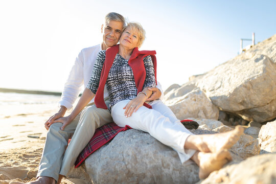 Senior couple embracing on beach enjoying retirement