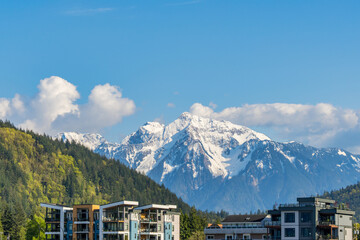 Modern residential buildings against snowy mountain landscape