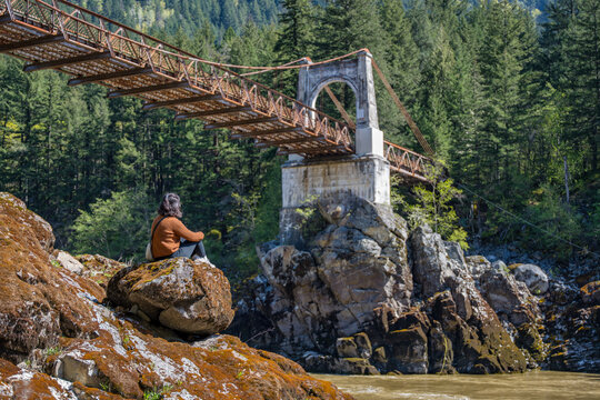 Woman contemplating Old Alexandra Bridge in British Columbia, Canada